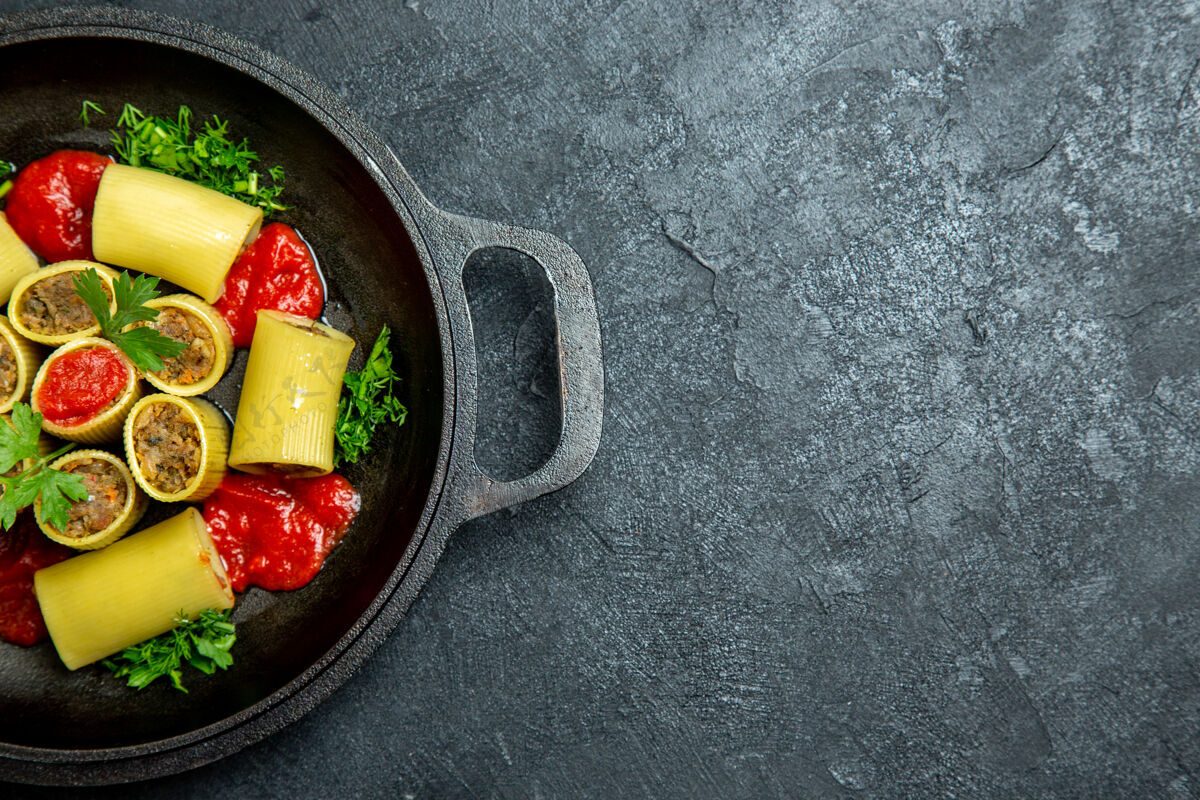 盘子顶视图生意大利面食与肉绿色和番茄酱内锅上一个黑暗的地板面食生的肉膳食