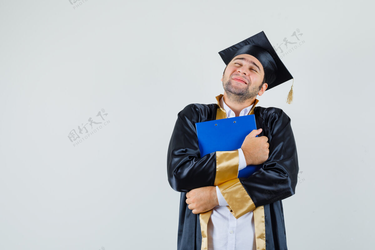 男人穿着毕业制服的年轻人抱着剪贴板 看上去很平静前视图成人衬衫制服