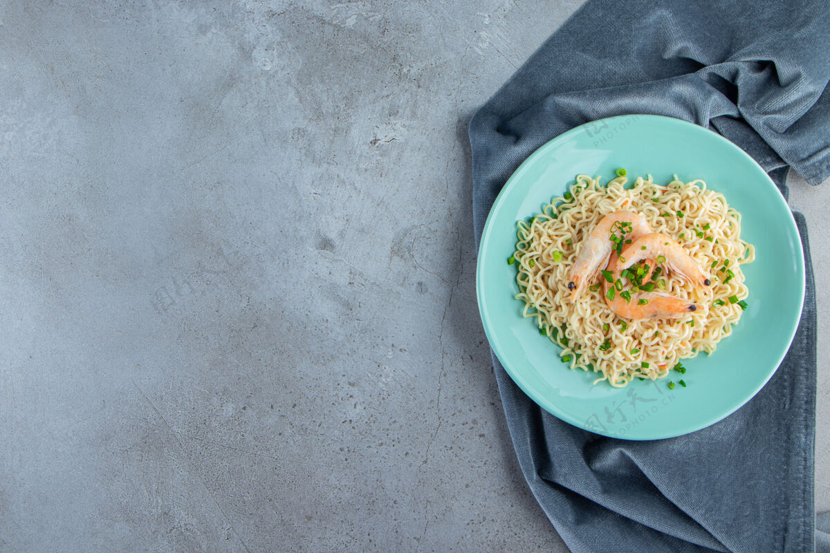 盘子面条和虾放在一块布上 放在大理石背景上布料意大利面午餐