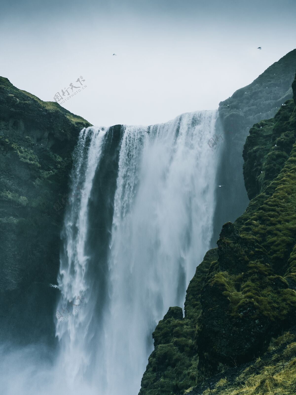 运动垂直拍摄的斯科加福斯瀑布在冰岛一个阴沉的日子瀑布美景观