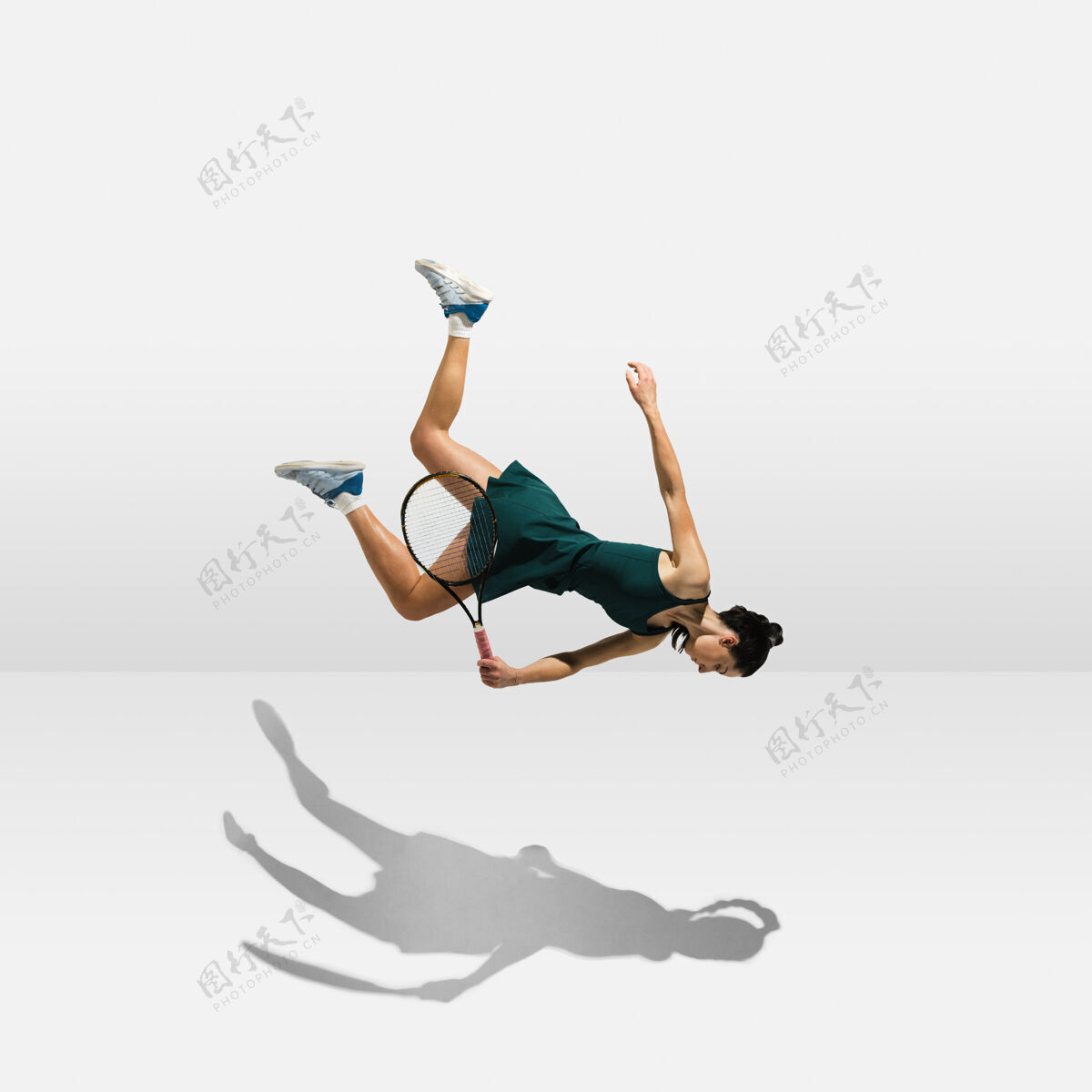 美丽年轻的职业女运动员悬浮在空中 一边打网球一边在白墙上孤立游戏动作专业