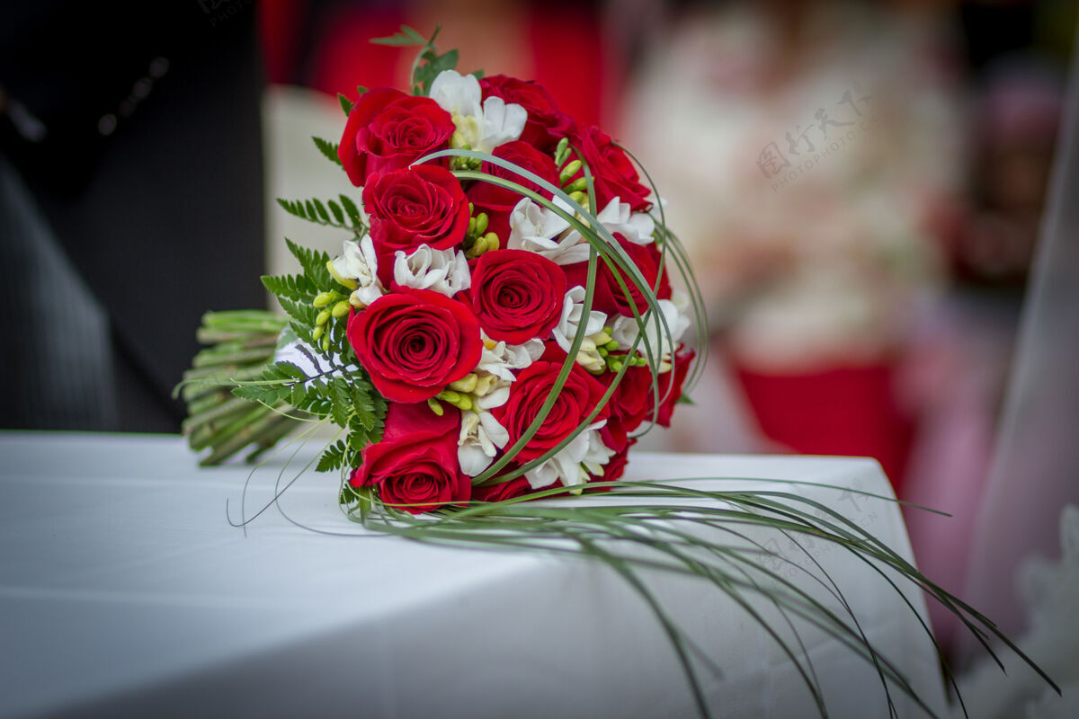 花蕾桌上摆着红玫瑰的婚礼花束白色花特写