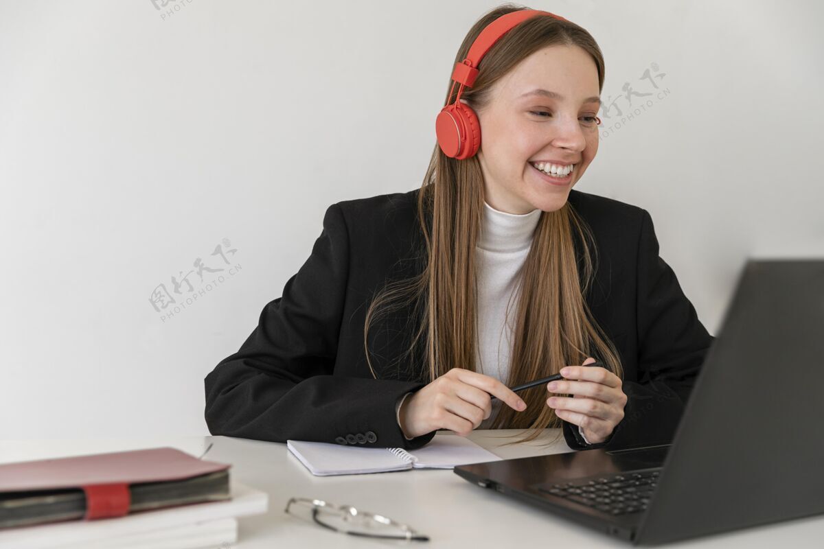 耳机中等身材的女人用笔记本电脑工作技术在工作水平