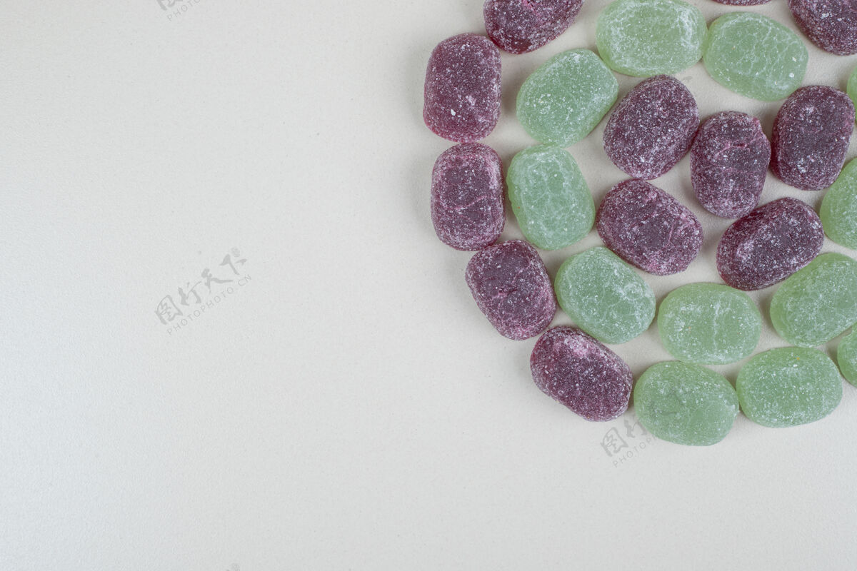 甜点绿色和紫色果冻糖果米色表面糖果什锦果酱