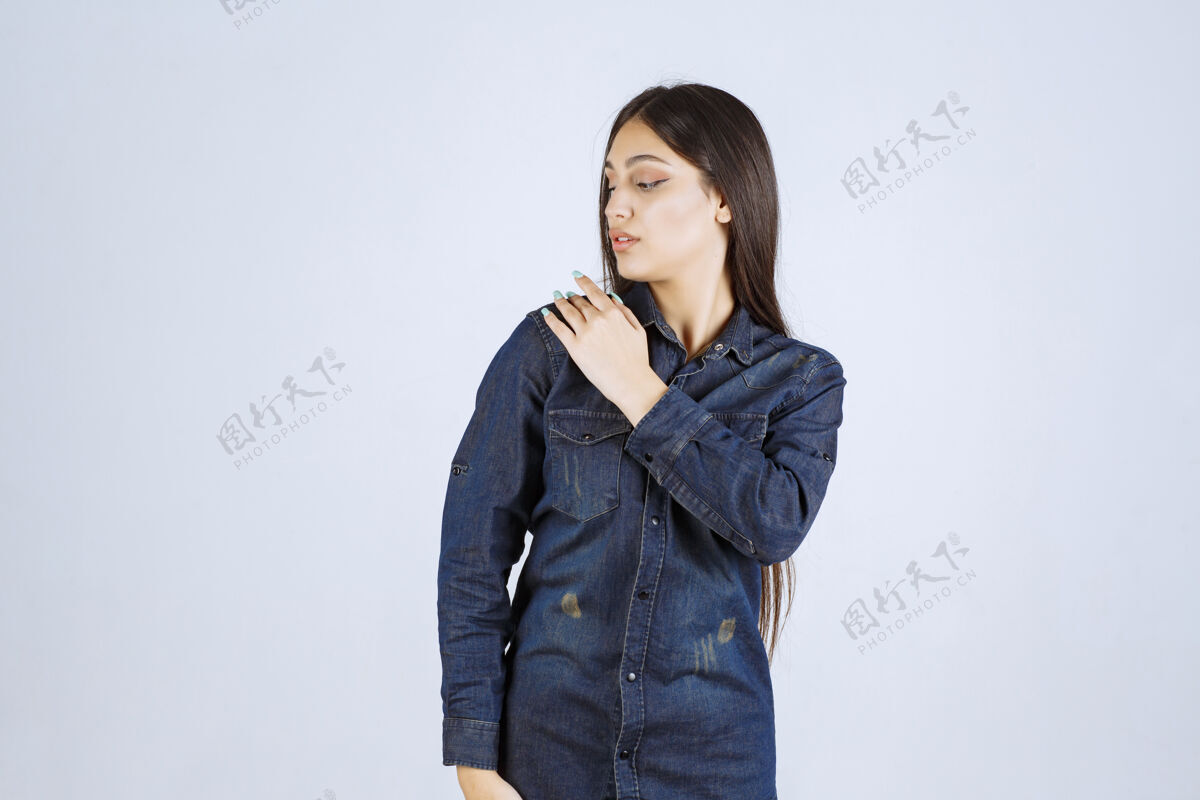 冷静穿着牛仔衬衫的年轻女子摆出中性姿势 没有任何反应呼吁女人放松