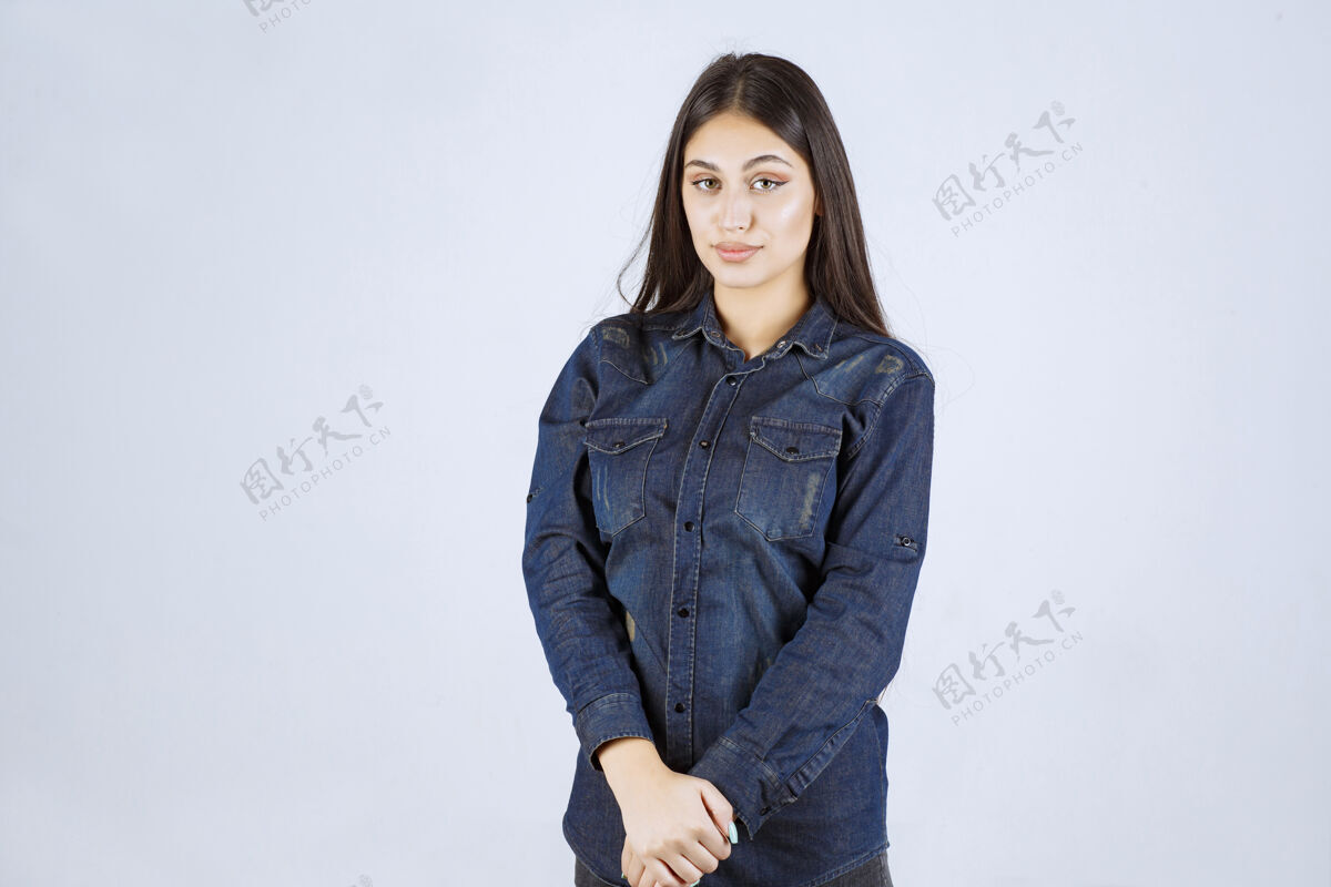 工人穿着牛仔衬衫的年轻女子摆出中性姿势 没有任何反应女性冷静聪明