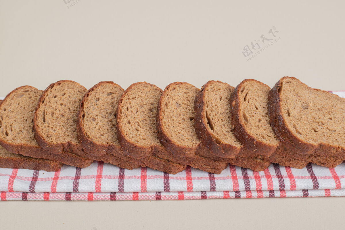 切片把新鲜的棕色面包片放在桌布上脆营养美食