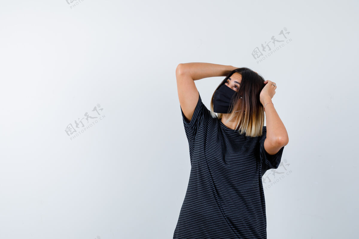 时尚一位身穿黑色礼服 戴着医用面罩的女士 双手抱在头上 面带沉思 俯视前方女士医疗头