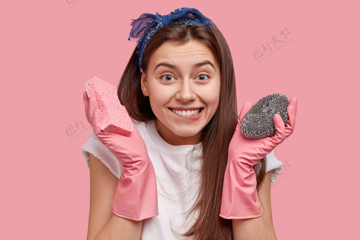 海绵头上戴着头巾拿着清洁用品的年轻女子成人人清洁