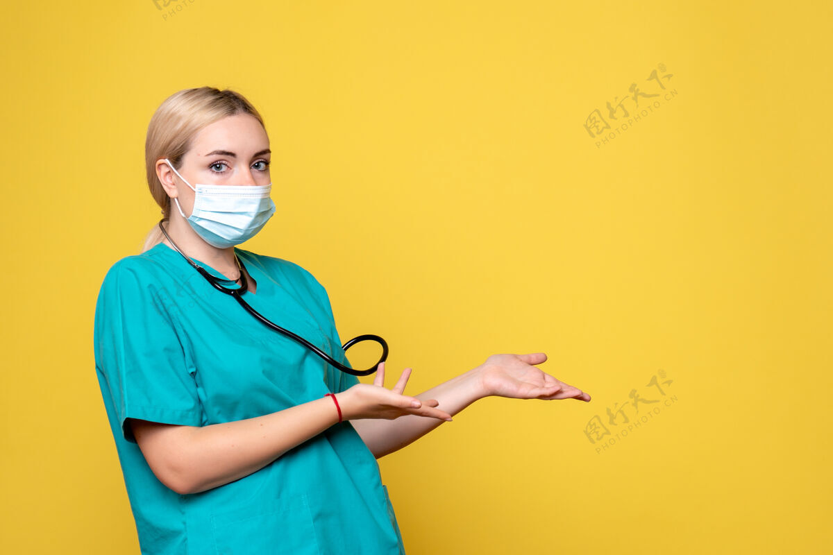专业前视图：穿着医用衬衫和面罩的女医生 医院护士covid-19大流行医护人员女性医学微笑