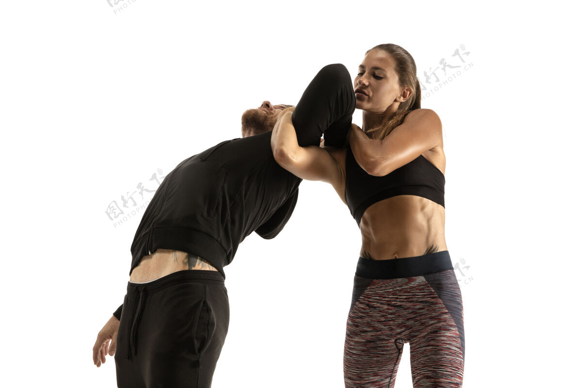 运动员穿黑色衣服的男人和在白色工作室墙上战斗的运动女人运动冲突拳击手