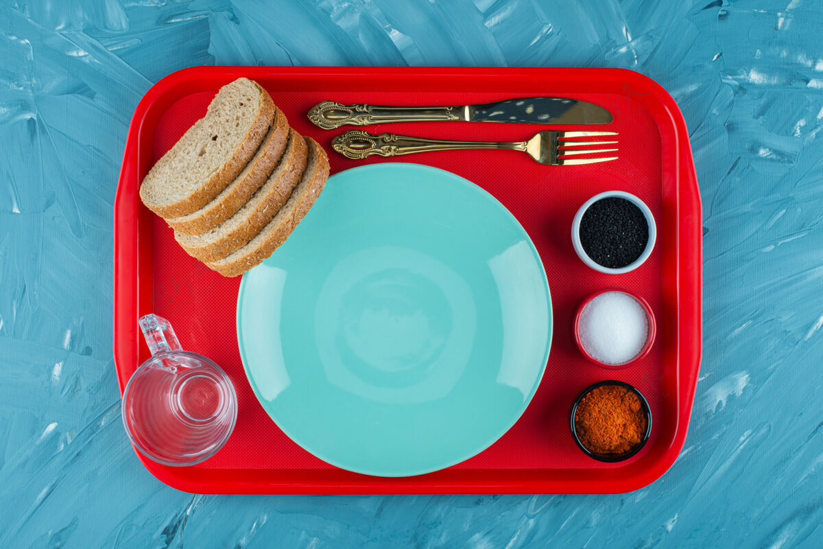 糕点一个红色的盘子 空的蓝色盘子里放着切片的棕色面包和香料面包盐红色