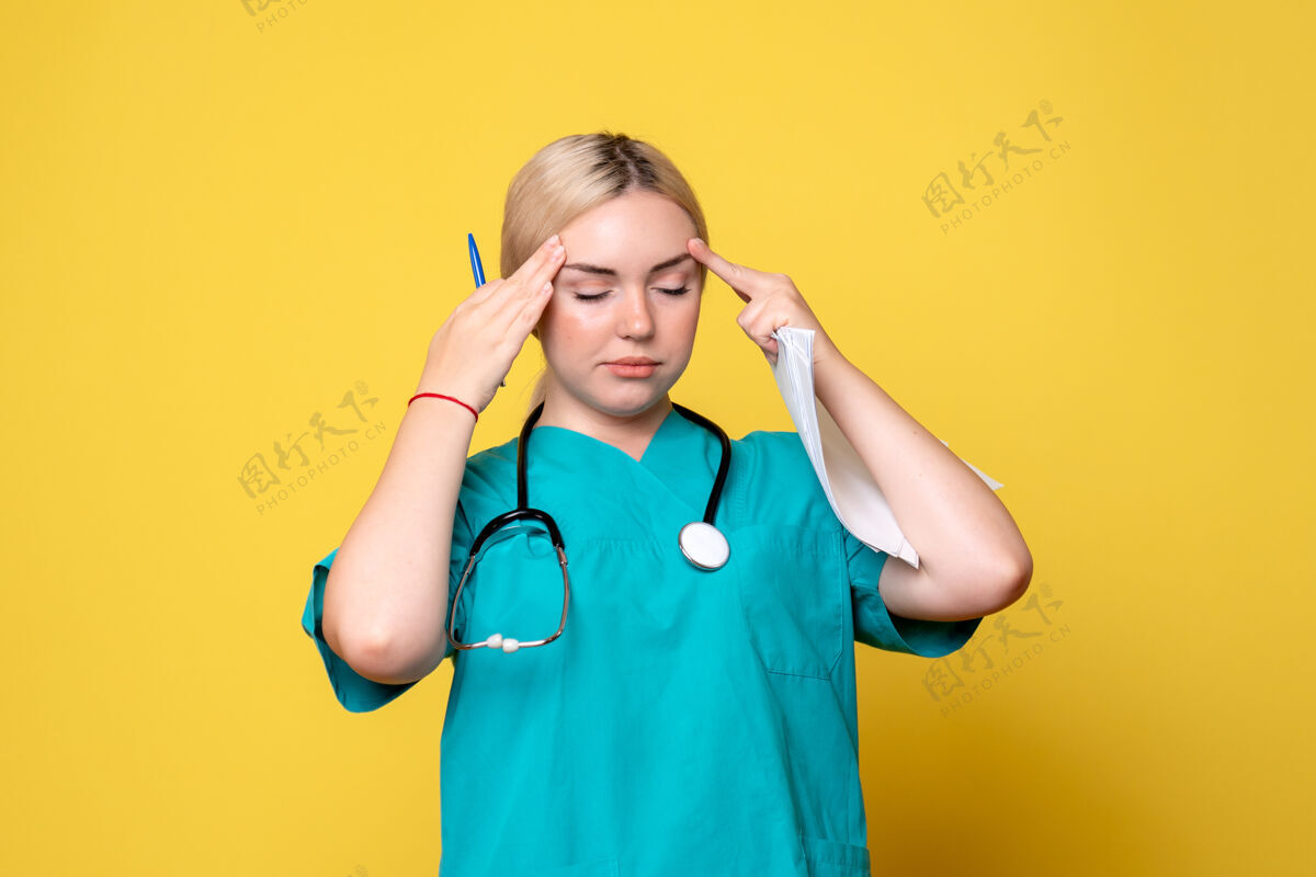 分析正面图女医生拿着头痛的分析和论文 冠状病毒健康医疗中心护士医院黄色女人健康