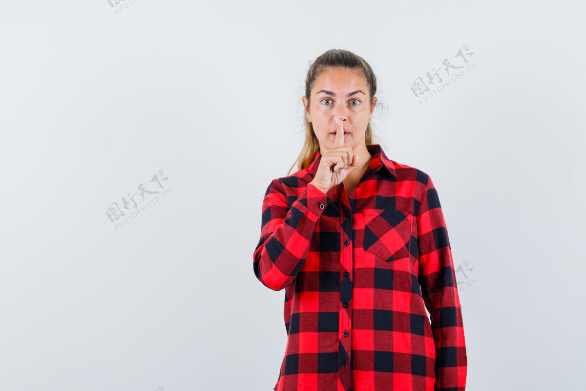人穿着格子衬衫的年轻女士表现出沉默的姿态 看上去很小心前面成人显示