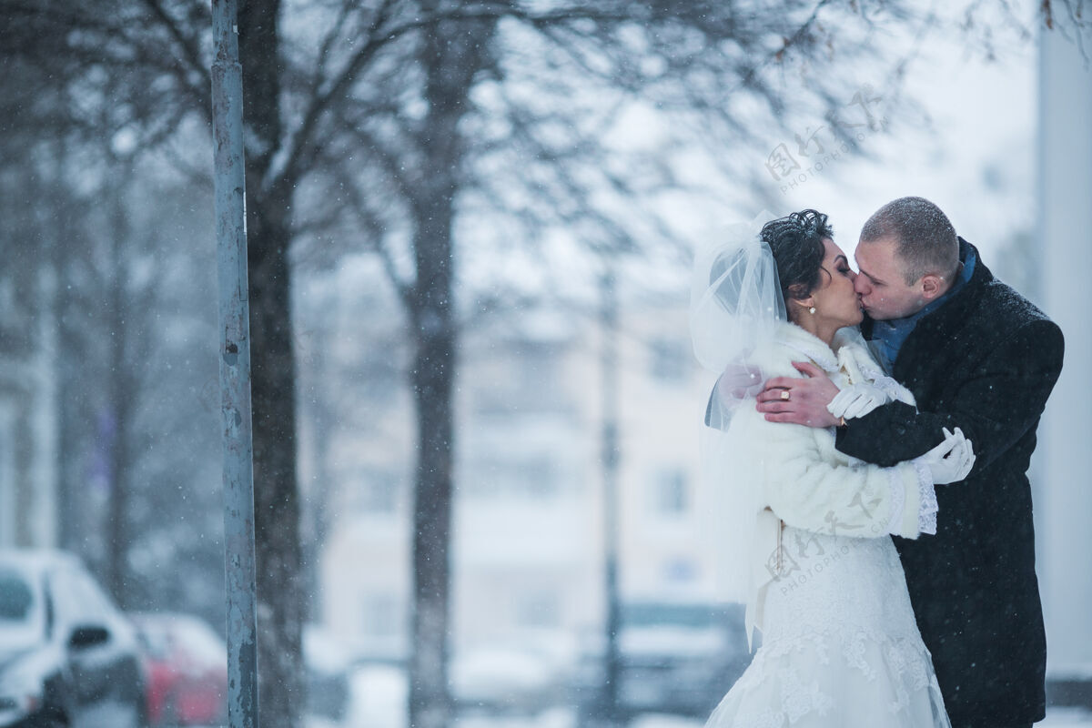 新郎新郎新娘在雪中行走在欧洲城市雪快乐流动