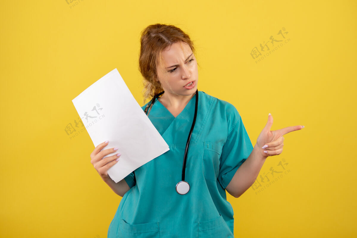 微笑黄墙上穿着医疗服的女医生手持分析图病毒女医生听诊器