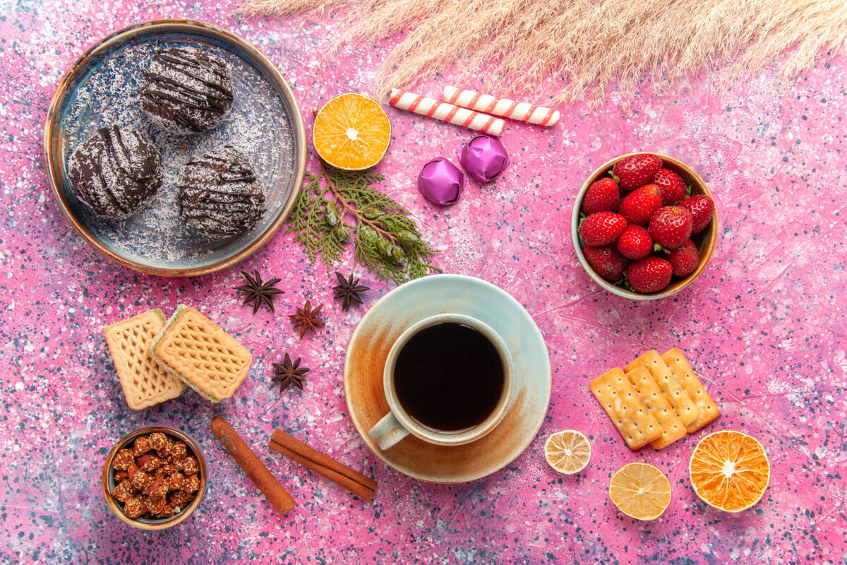 咖啡俯瞰巧克力蛋糕与华夫饼和一杯粉红色的茶水果茶糖果