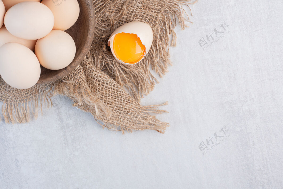 美味在大理石桌上的一块布上 蛋黄旁边放一碗鸡蛋有机生的美味
