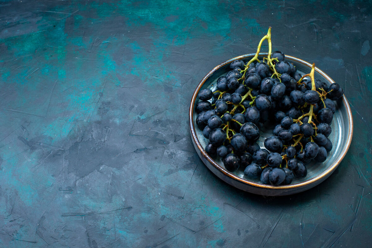 食物在深蓝色桌子上的托盘里看到黑葡萄黑莓盘子蓝莓