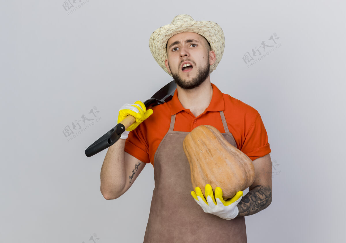 男戴着园艺帽和手套的未被雇佣的男园丁拿着铲子和南瓜花园空间黑桃