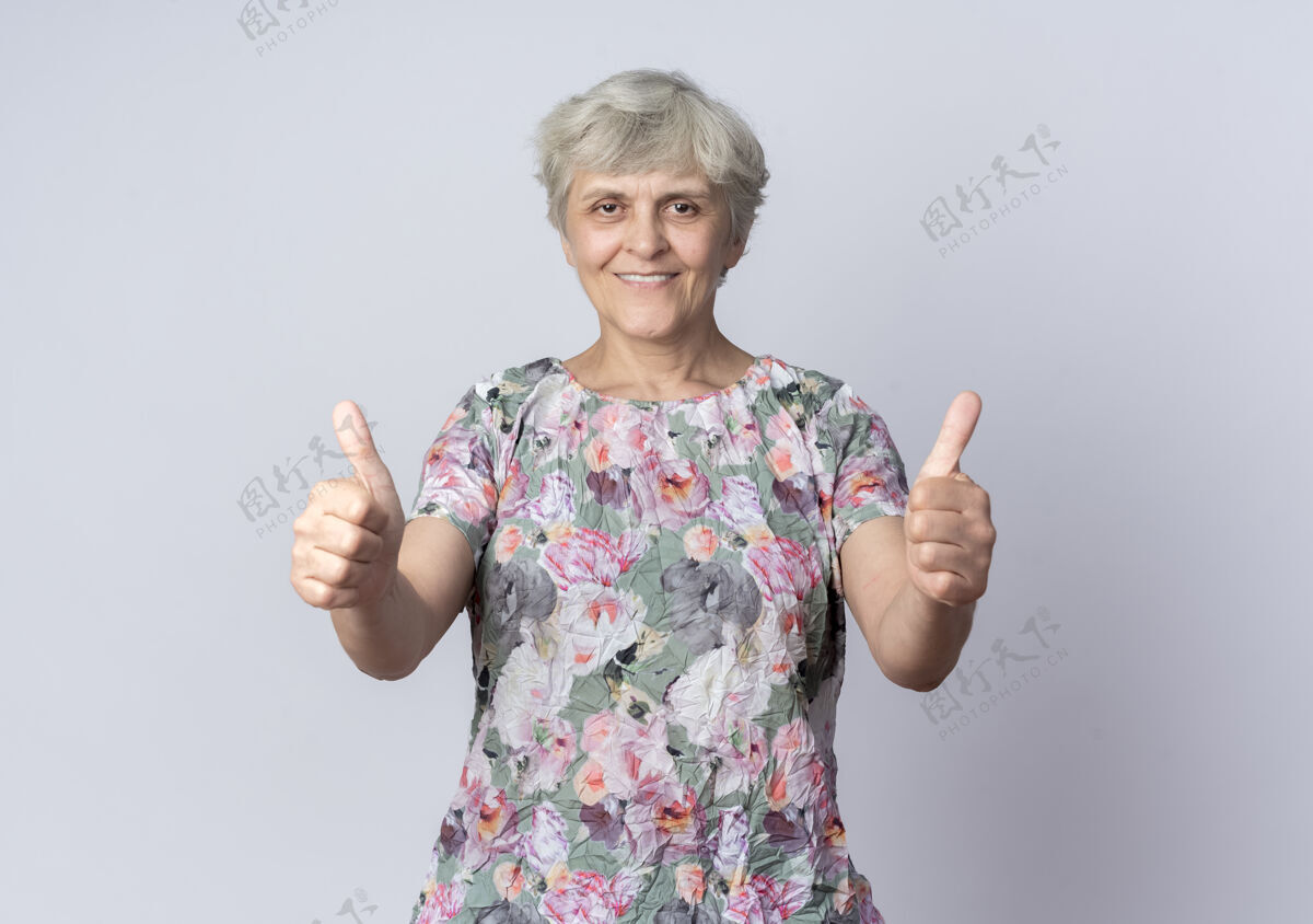 老人微笑的老妇人竖起大拇指 两只手孤立在白墙上女人拇指老