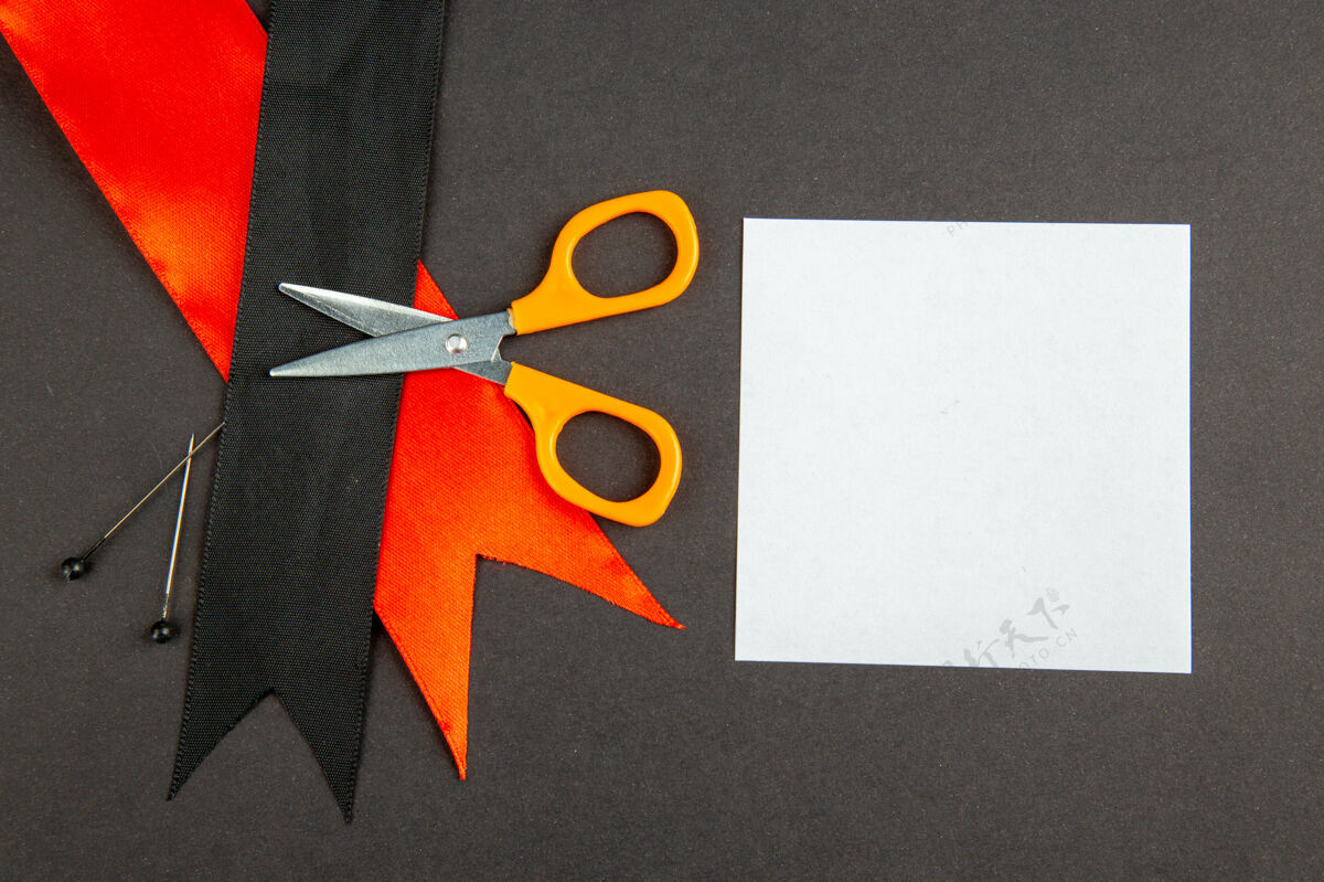 剪刀顶视图黑色蝴蝶结与红色蝴蝶结和剪刀在黑暗的背景测量视图黑色蝴蝶结