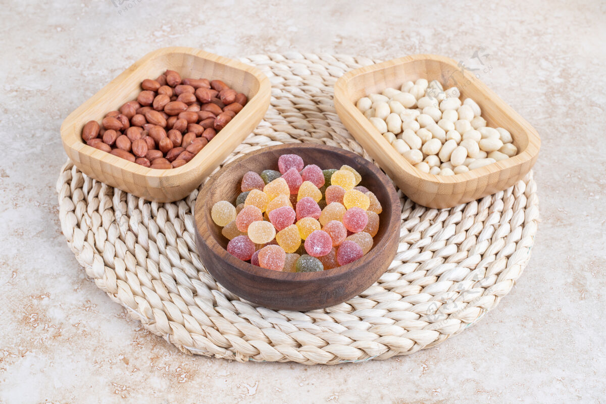 糖果在大理石表面放上一碗装糖果和花生仁的木碗花生坚果甜点