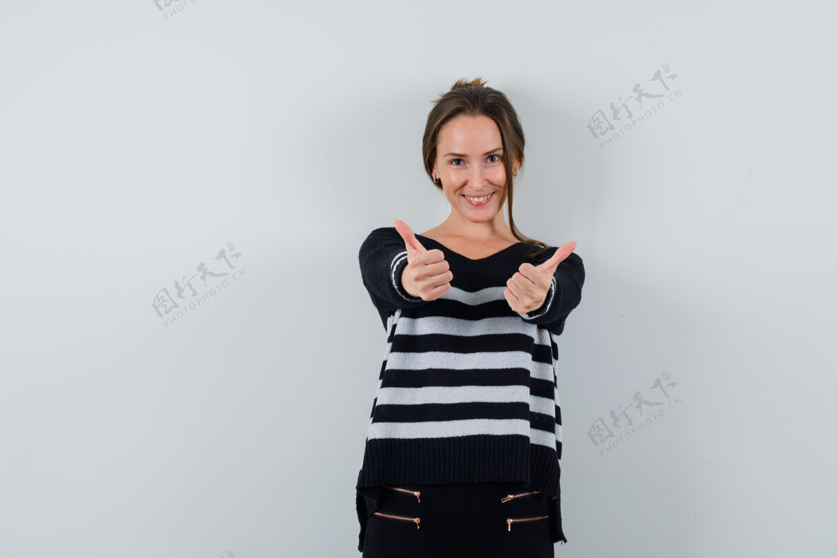 清洁穿衬衫的年轻女士竖起大拇指 看上去很高兴衬衫美丽头部