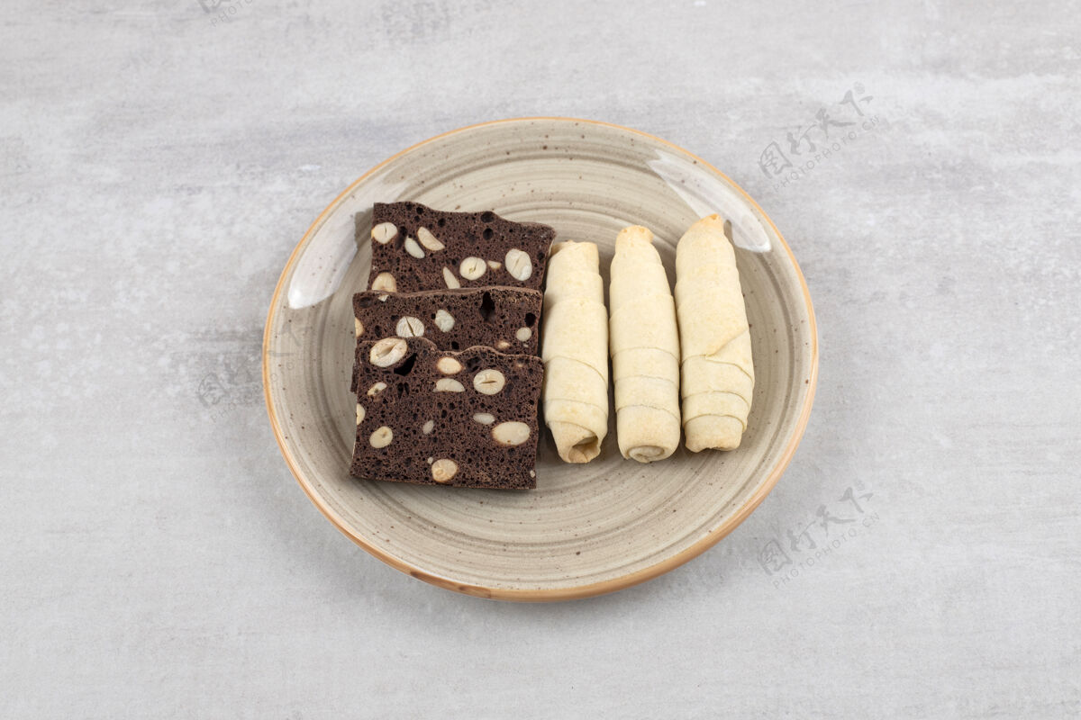 烘焙自制巧克力布朗尼和卷饼干放在盘子上 放在大理石桌上甜点自制饼干