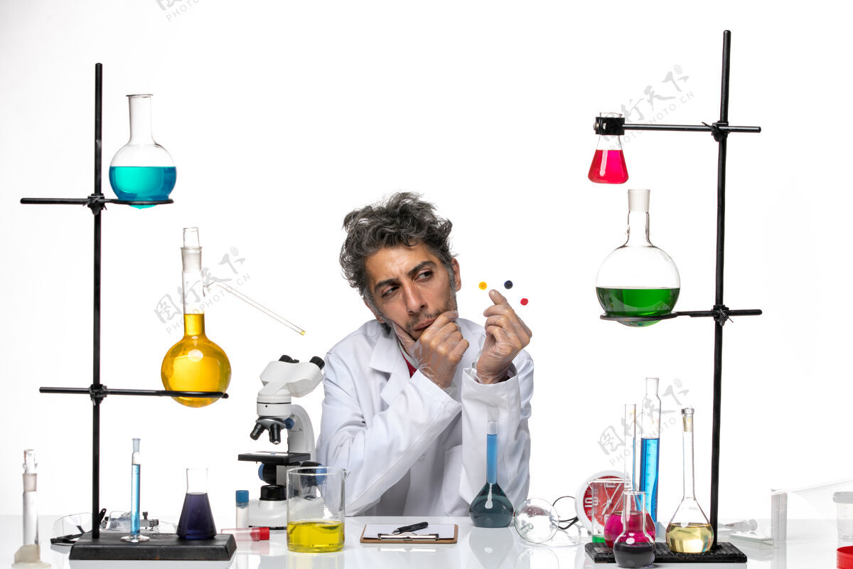 化学正面图男性科学家拿着样品在桌子前 白色背景上的解决方案冠状病毒健康实验室covid实验室研究实验