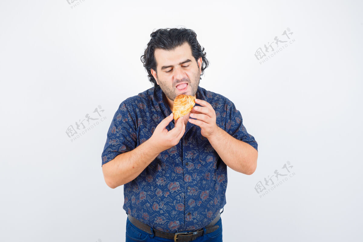 衬衫成熟的男人吃糕点产品在衬衫和饥饿的样子前视图电器男性新鲜