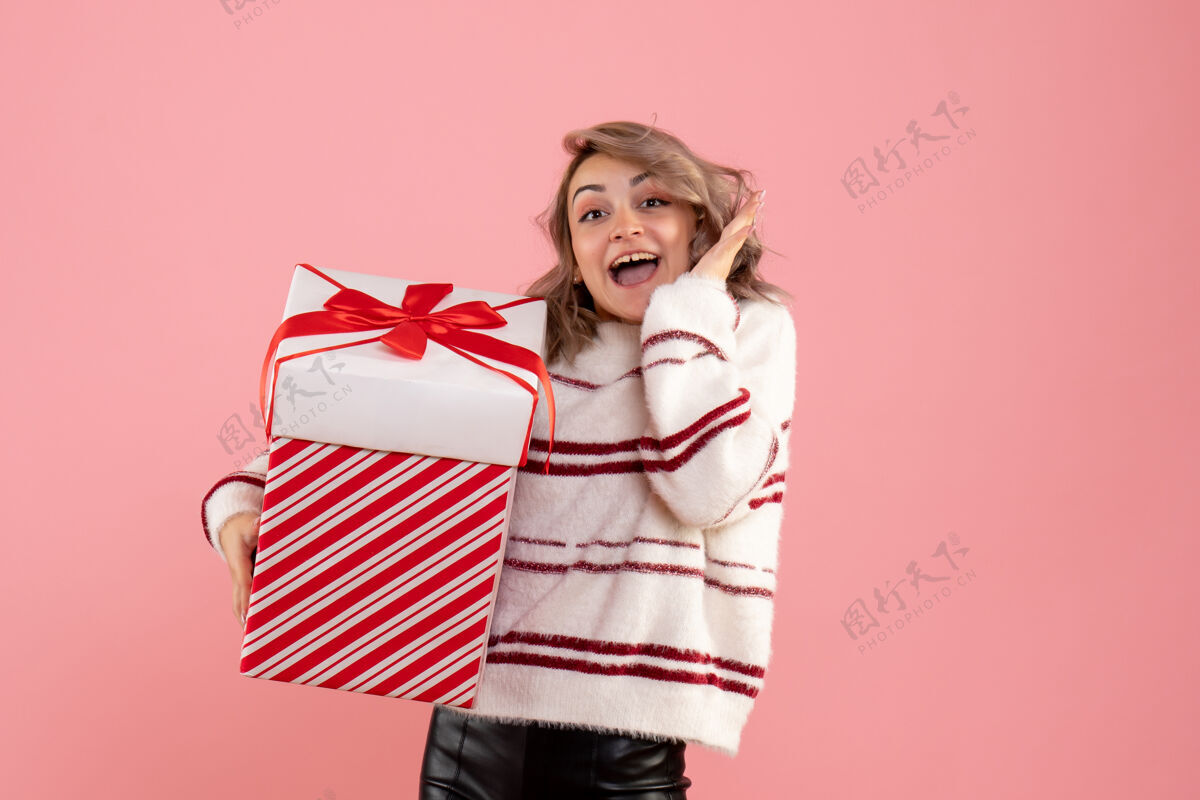 礼物前视图年轻女性与圣诞节礼物粉色肖像漂亮