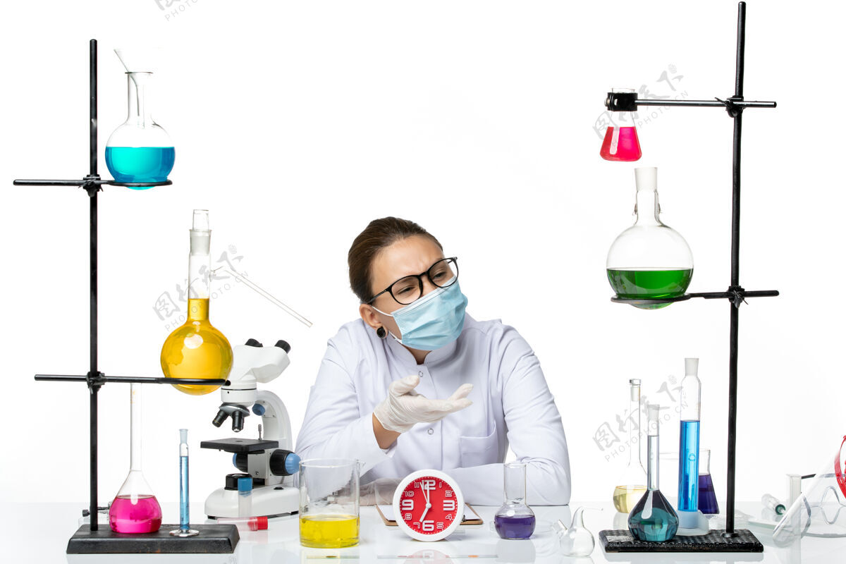面罩前视图穿着医疗服的女化学家戴着面罩坐在白色背景上的溶液飞溅实验室病毒化学冠状病毒视图科学病毒