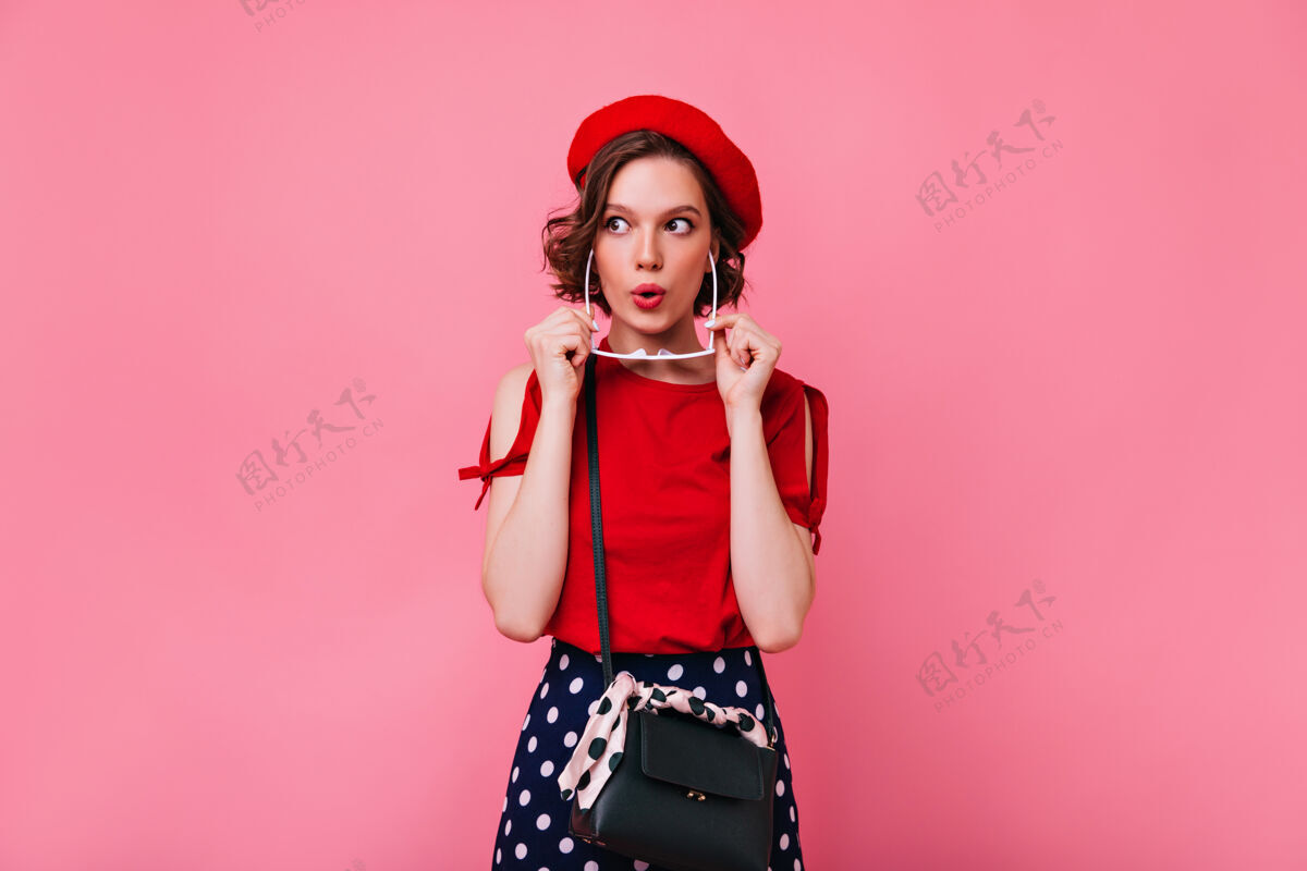 成人积极的白人女孩戴着可爱的红色贝雷帽 表达着兴趣室内照片是一位优雅的法国女模特 留着短发模特快乐美丽
