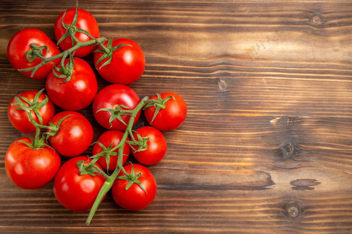素食在棕色的木桌上俯瞰红色的西红柿和成熟的蔬菜饮食成熟西红柿