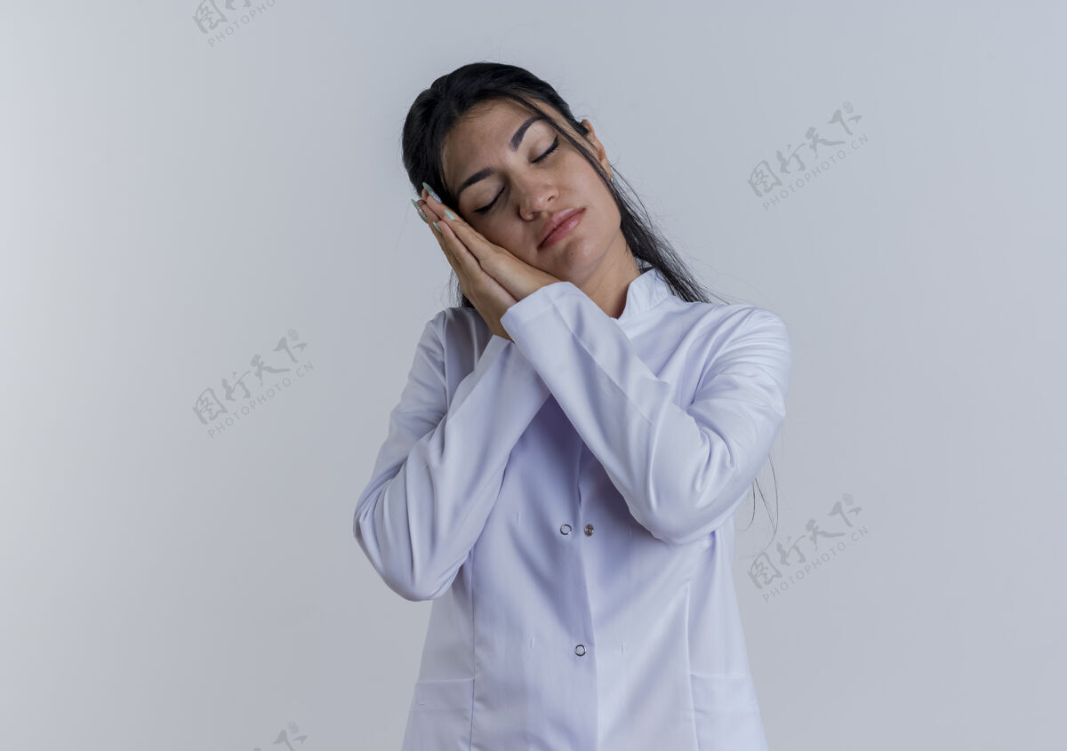 医学疲惫不堪的年轻女医生穿着医用长袍做着闭眼睡觉的姿势穿手势成人
