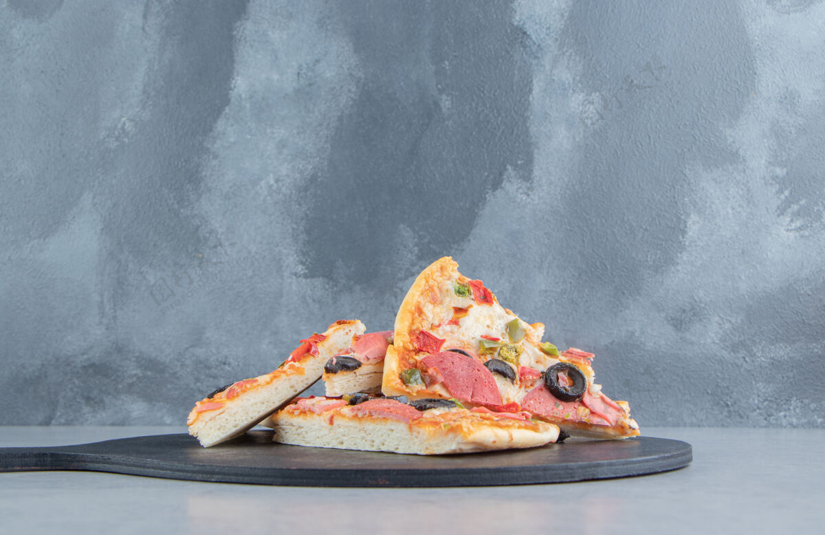 快餐一小堆披萨片放在一块黑色的大理石板上片美味垃圾食品