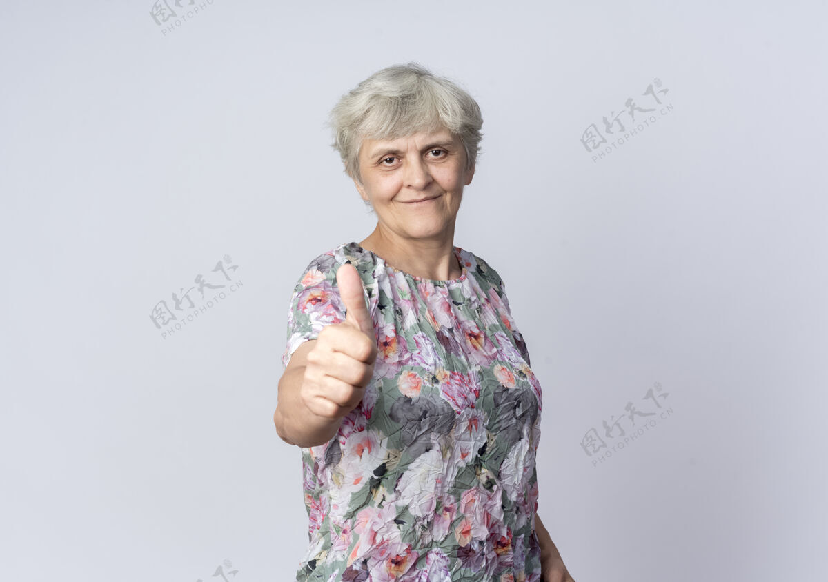 起来高兴的老妇人竖起大拇指孤立地站在白墙上老的拜托老的