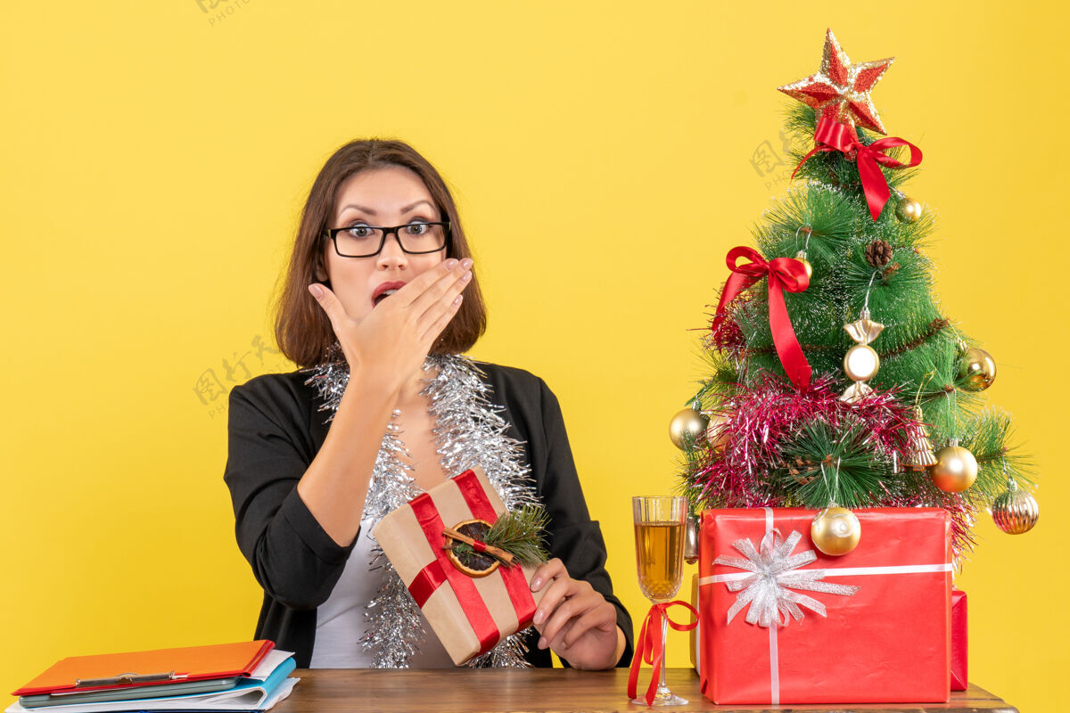 人新年的心情与美丽的惊喜商务女士西装革履 戴着眼镜 坐在一张桌子在办公室里人漂亮成人