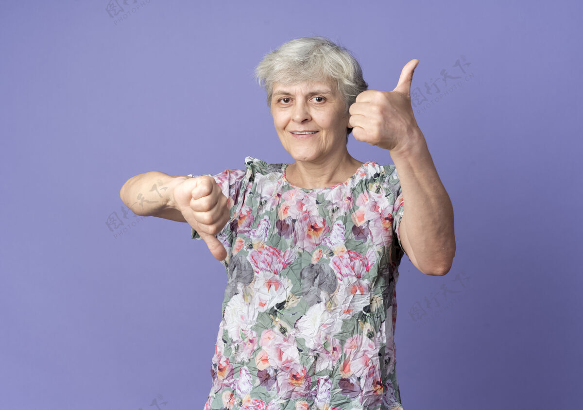 向上高兴的老太婆竖起大拇指 竖起大拇指孤立在紫色的墙上大拇指紫色老人