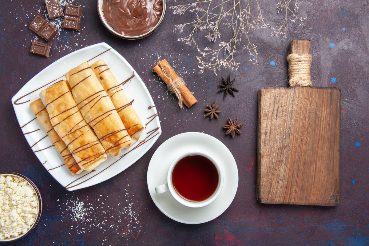 甜点俯瞰美味的巧克力甜点和一杯茶在黑暗的地板上甜烤饼干甜点糖蛋糕巧克力美味糕点