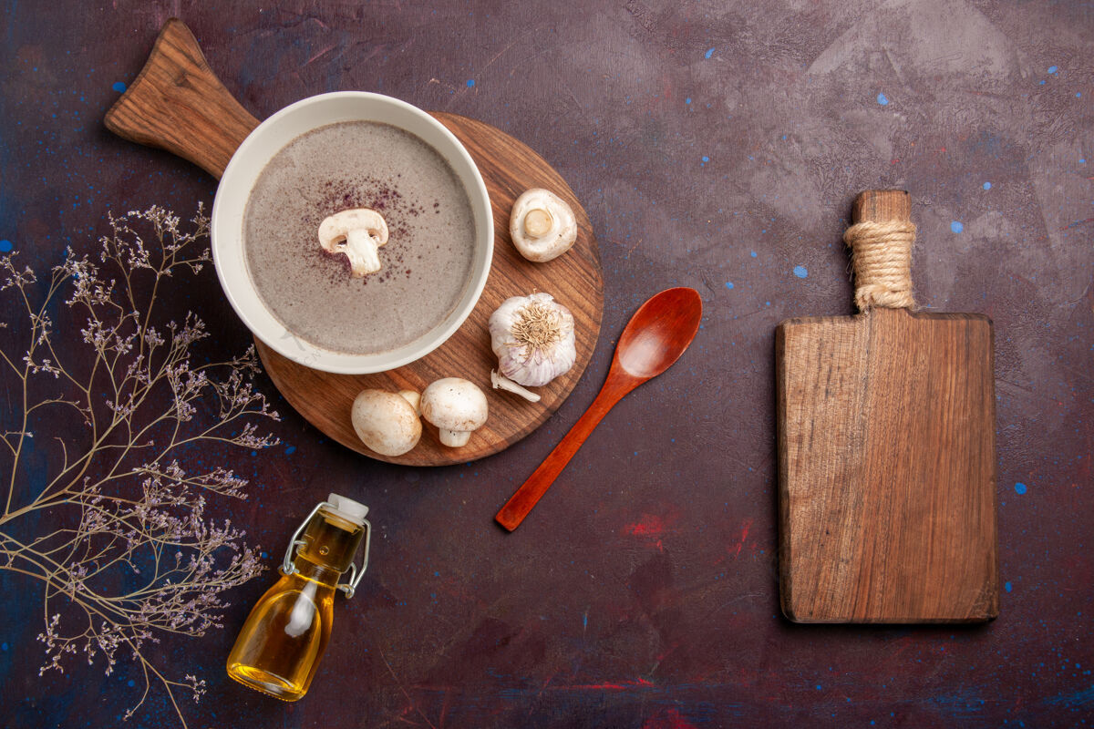 汤俯瞰美味的蘑菇汤与新鲜蘑菇和油在黑暗的桌子上油木头封闭