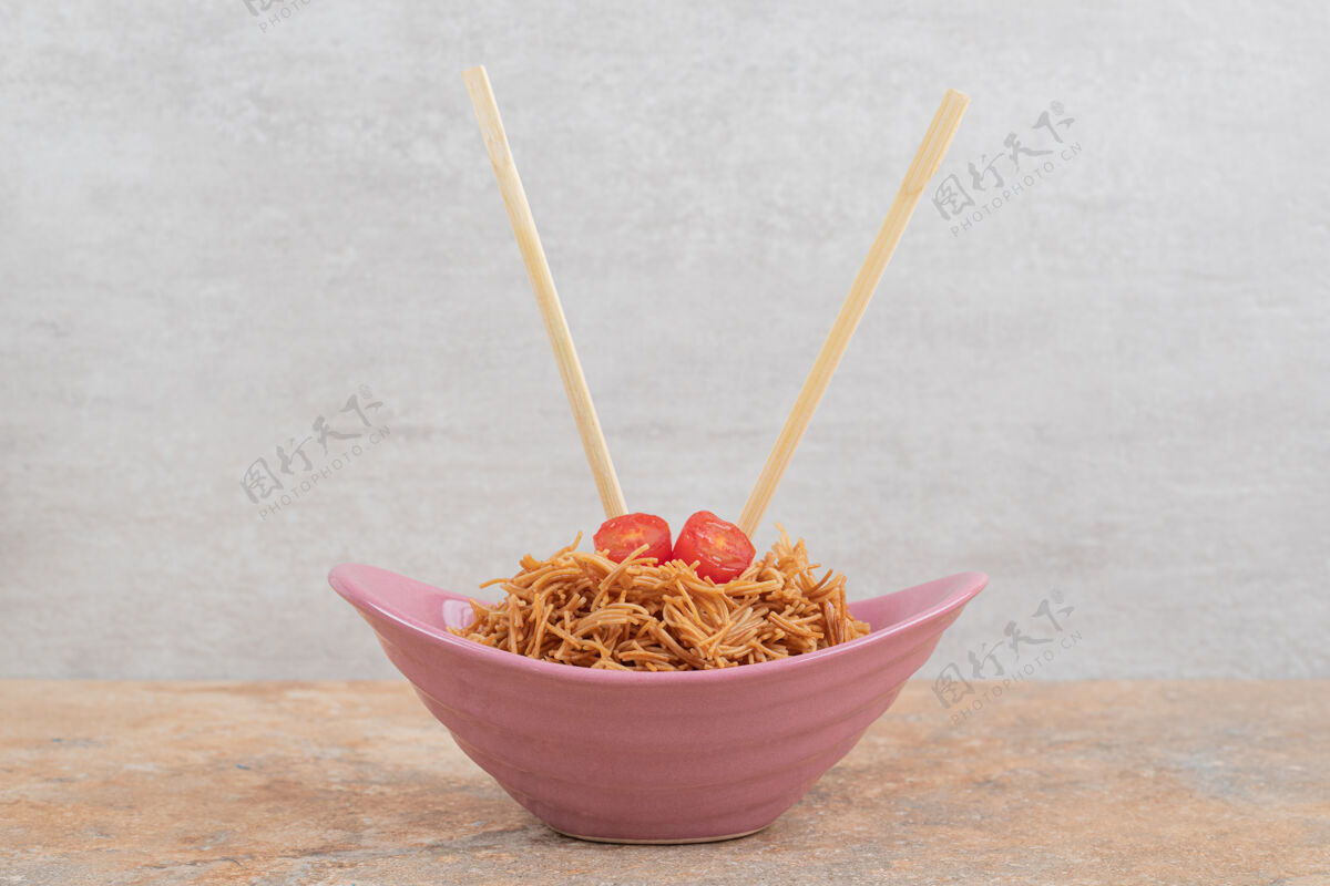 薯条用筷子在粉红色的碗里炸西红柿粉丝高质量的照片美味美食烹饪