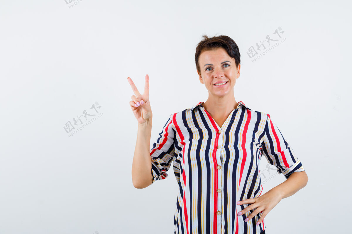 老年人成熟的女人表现出平和的姿态 穿着条纹衬衫的手放在腰上 看起来很自信 前视图姿势人前面