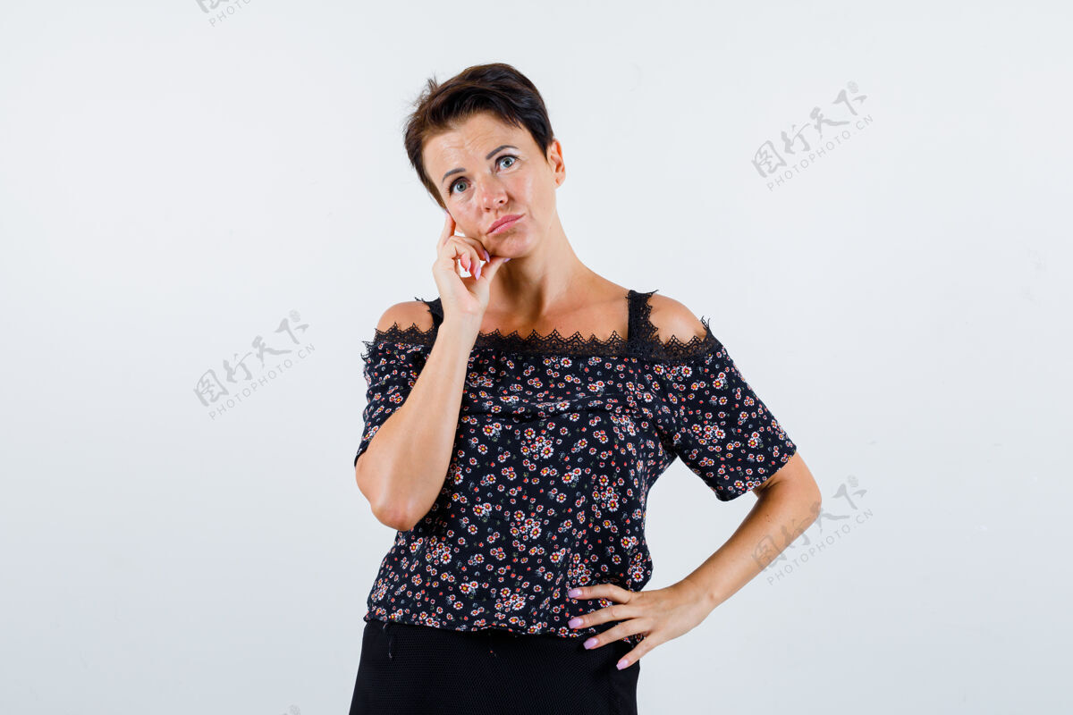 老年穿衬衫的成熟女人站在思考的姿势 手放在腰上 看起来犹豫不决 前视年龄美容老年人