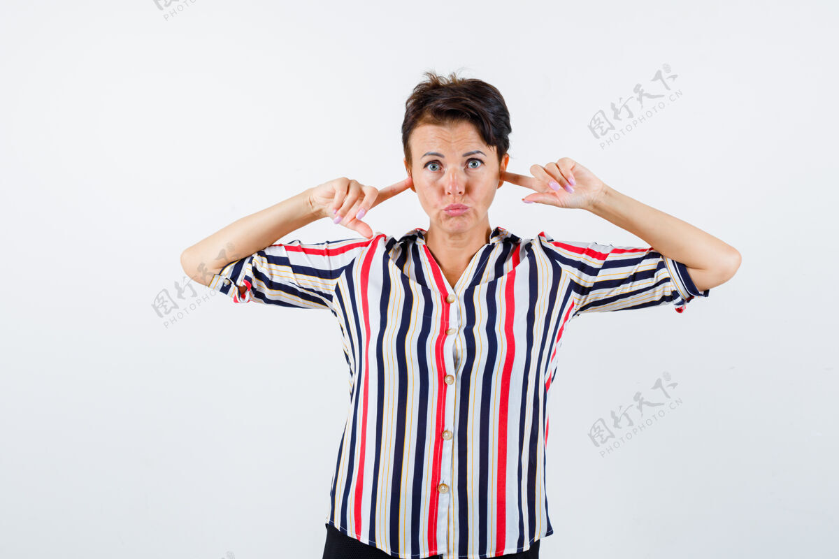 商务穿条纹衬衫的成熟女人用食指堵住耳朵 表情严肃 正面看活跃目录人