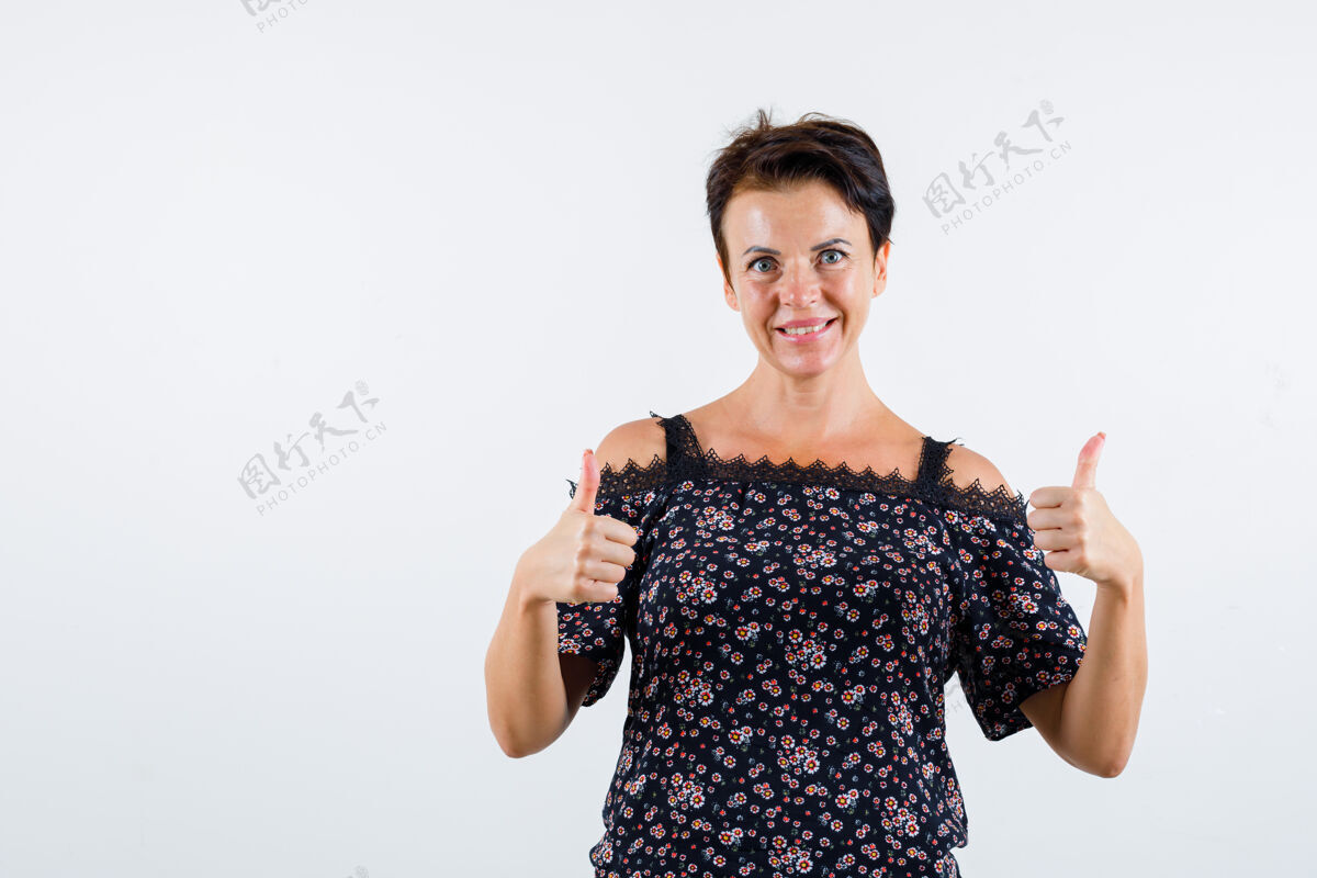 女人成熟的女人在花衬衫 黑色裙子上竖起大拇指 看起来很欢快正面图优雅人商务
