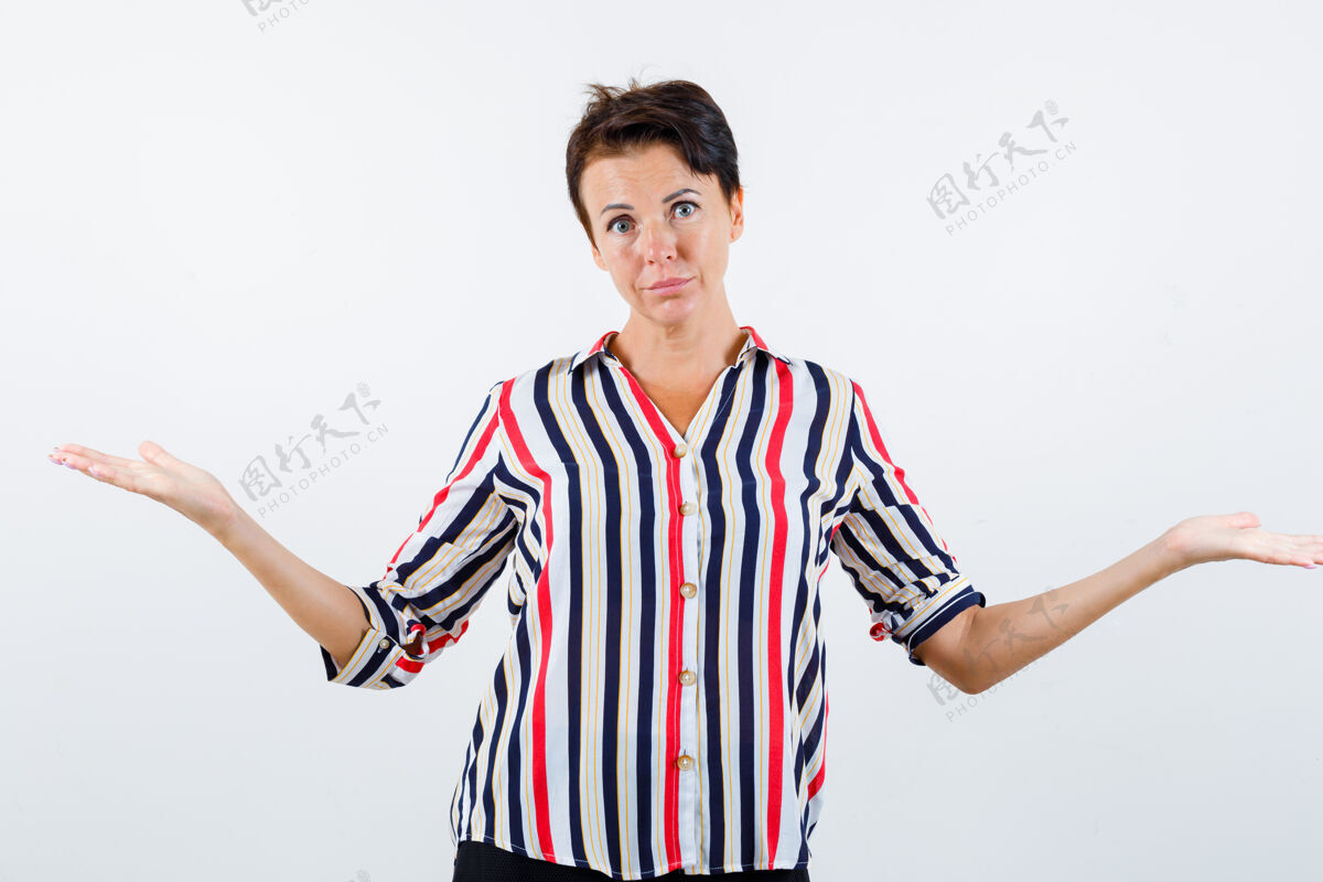 女人成熟的女人穿着条纹衬衫 表现出无助的姿态 看起来很困惑 前视图衬衫显示健身