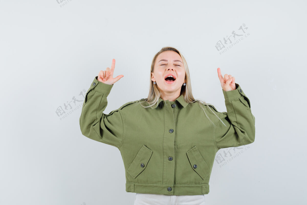 人身穿绿色夹克 牛仔裤的年轻女性一边尖声尖叫 一边俯视前方健康自然夹克