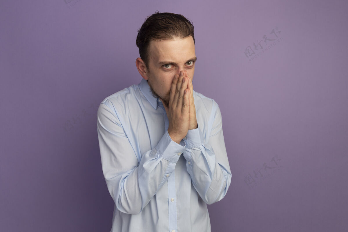 衣服未出柜的金发帅哥把手放在鼻子上孤立在紫色的墙上人人感情